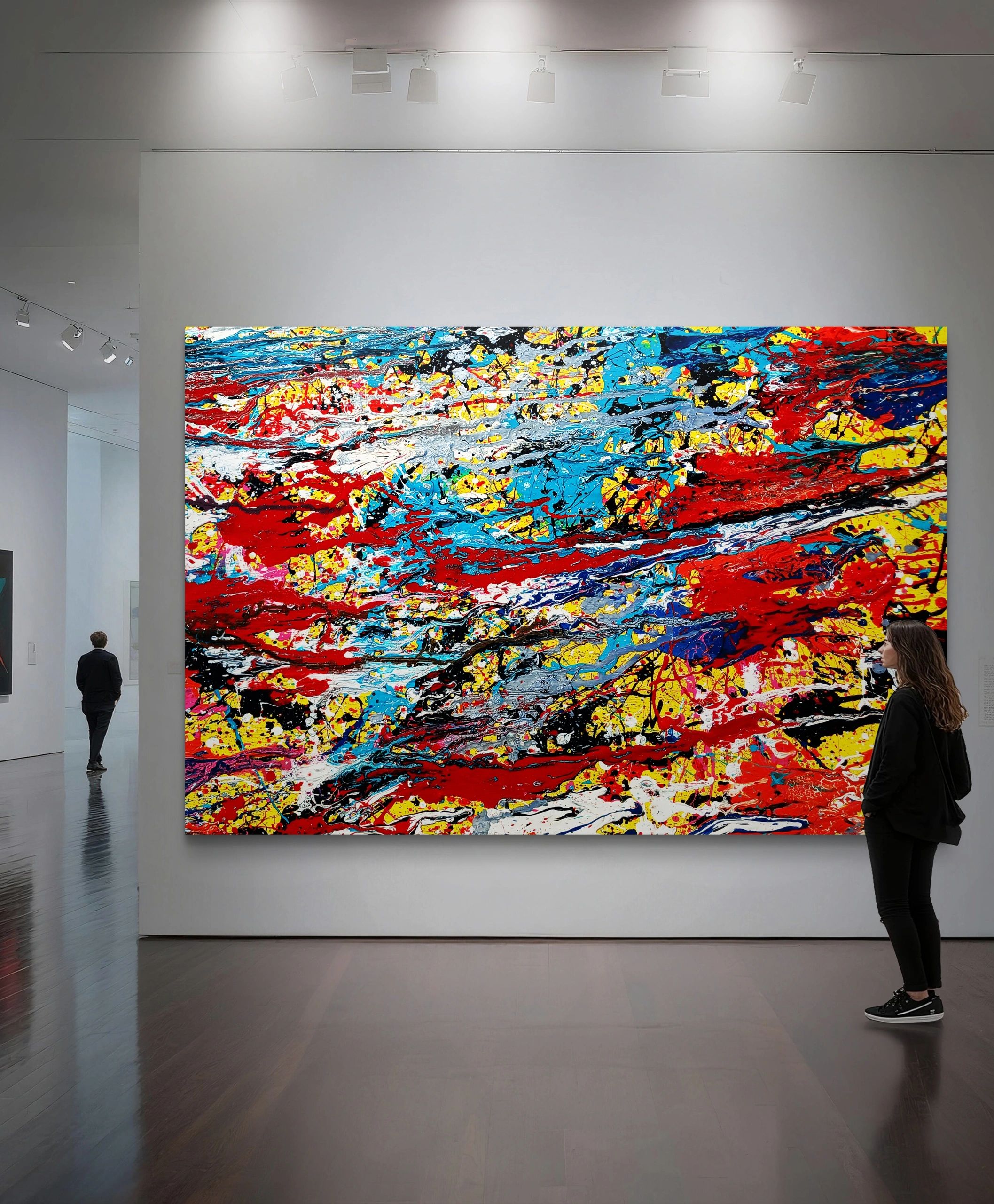 Large vibrant abstract painting with splashes of red, yellow, blue, and black in a modern gallery.