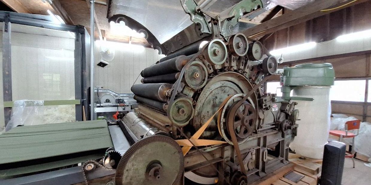 Vintage industrial machine with belts and rollers.
