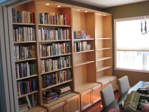 Wooden bookshelves filled with books in a cozy home office or study room.