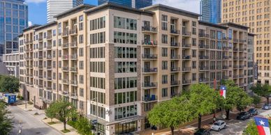 A residential building facade is being cleaned by a drone cleaning service. 