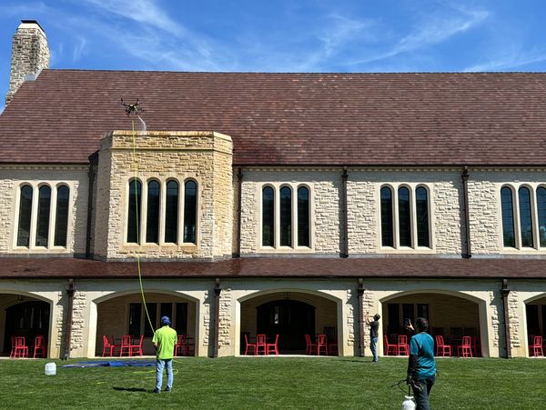 Drone operator cleaning a facade of the building using best cleaning method