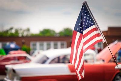 American flag on display with classic cars in the background.