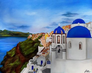 Scenic view of white buildings with blue domes by the sea under a bright sky.