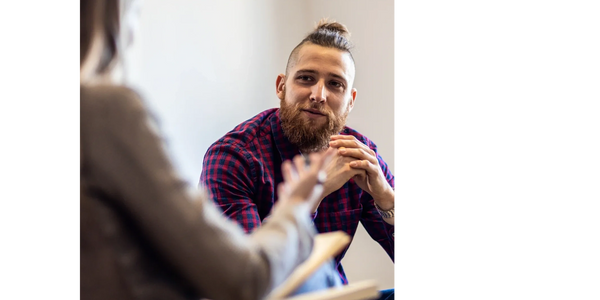 Man with a beard attentively listening during a conversation.