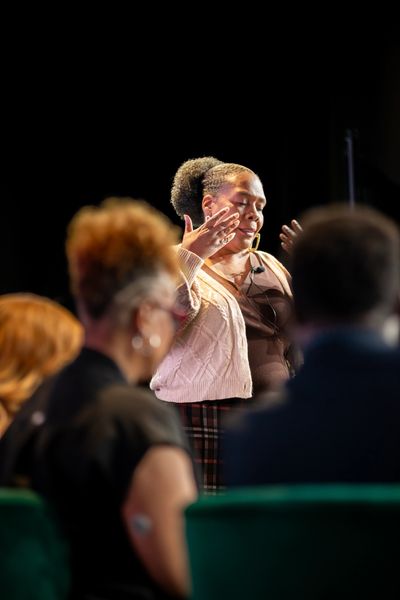 Woman speaking passionately in front of an audience.