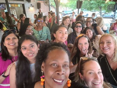A cheerful group selfie of diverse women at a lively gathering.
