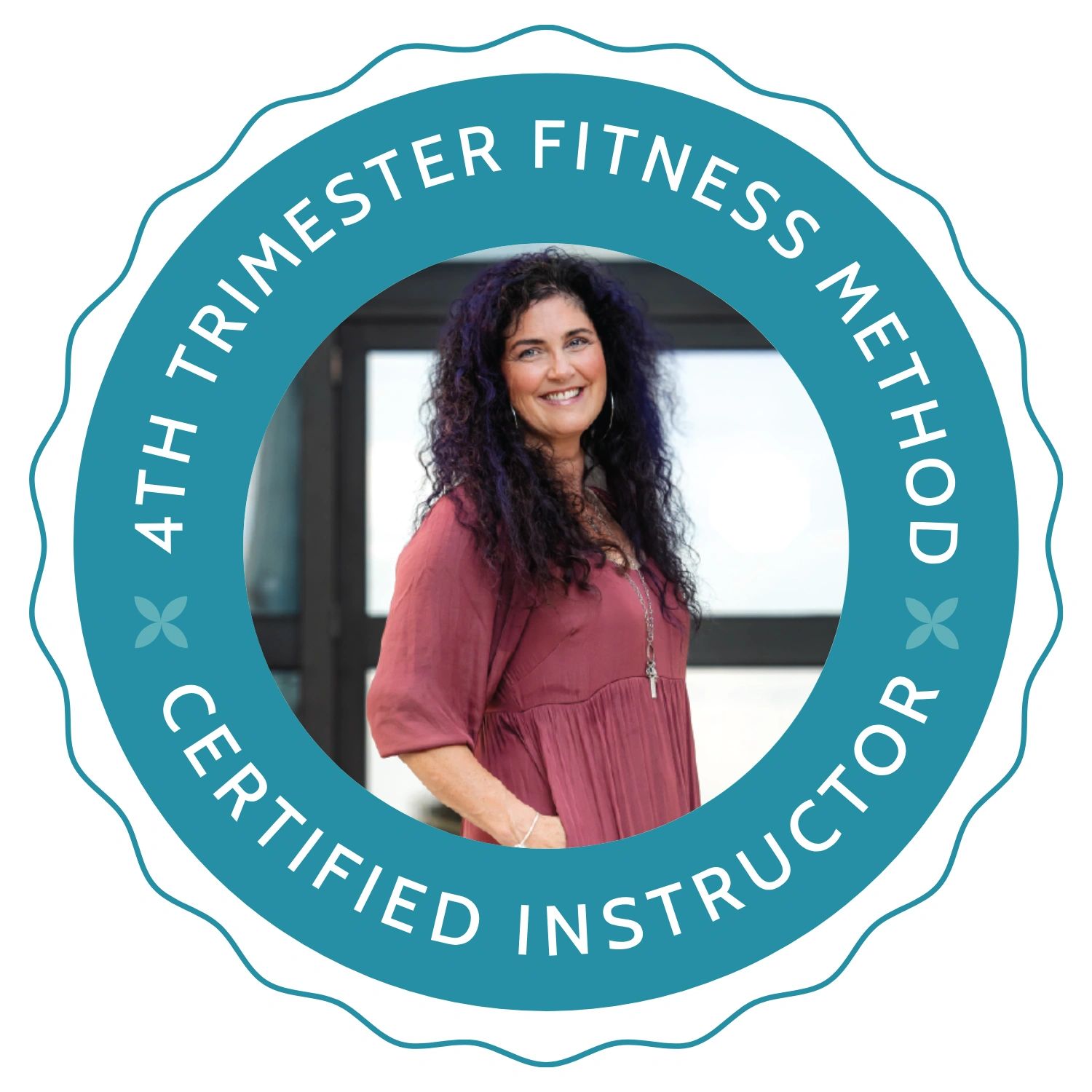 woman with black hair, maroon dress, her hands in her pockets. Teal ring with 4th trimester fitness