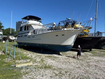 A large yacht docked on land with a person nearby.