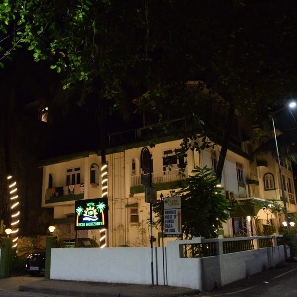 Hotel Belo Horizonte illuminated at night with decorative lights on trees.