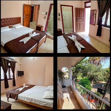 Cozy hotel room with double bed, balcony, and garden view.