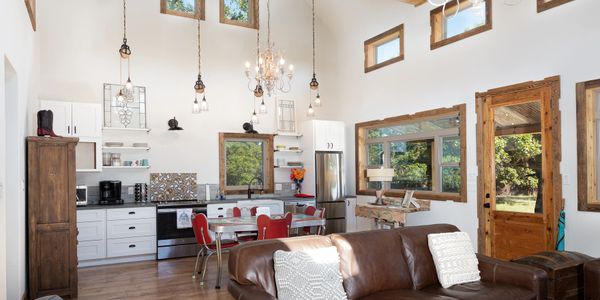 Modern farmhouse kitchen open to living room. Designed by Texas Hill Country Custom Homes builder.