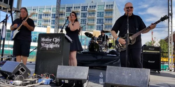 Motor City Wranglers band performing live on outdoor stage.