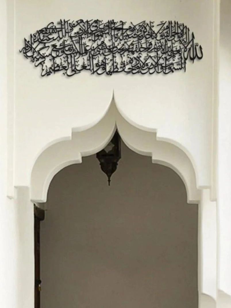 Decorative Arabic calligraphy above an ornate white archway.