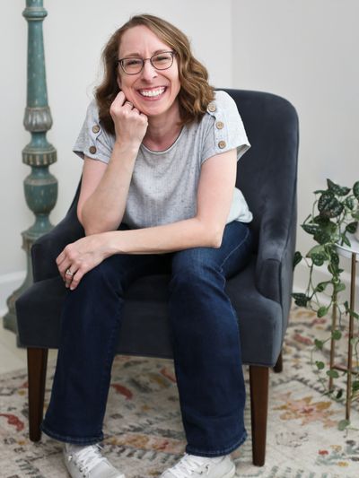 Woman smiling while sitting on a chair.