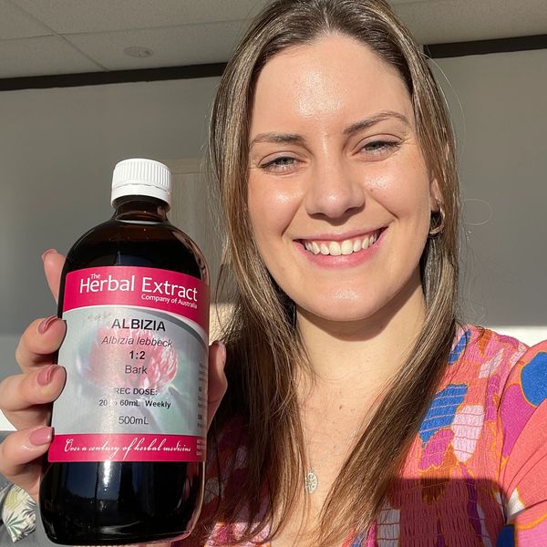 Jessica the naturopath holding a bottle of liquid herbal medicine 