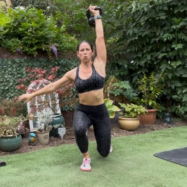 Woman exercising outdoors with a kettlebell.
