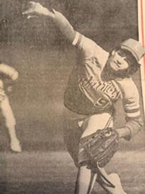 Vintage photo of a baseball pitcher mid-throw.