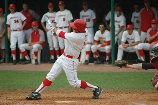 Baseball player swinging at a pitch.