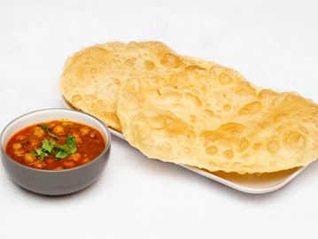 Indian meal of chickpea curry (chole) with puffed fried bread (bhature).