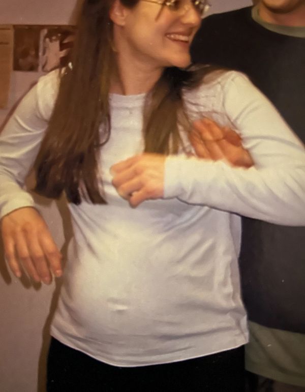 Expecting woman's abdomen supported by husband