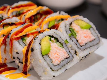 Close-up of sushi rolls with sauces.