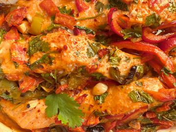 A colorful, cheesy baked dish with herbs and vegetables.