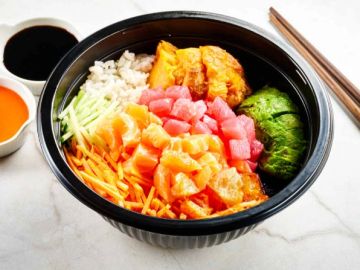 A colorful poke bowl with vegetables and raw fish.