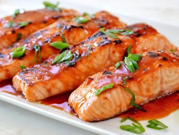 Grilled salmon with sauce and herbs.