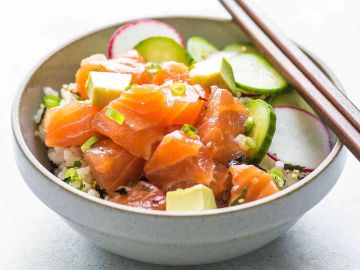 Bowl of salmon poke with vegetables and rice.