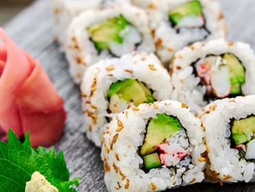 Close-up of sushi rolls with avocado and crab.