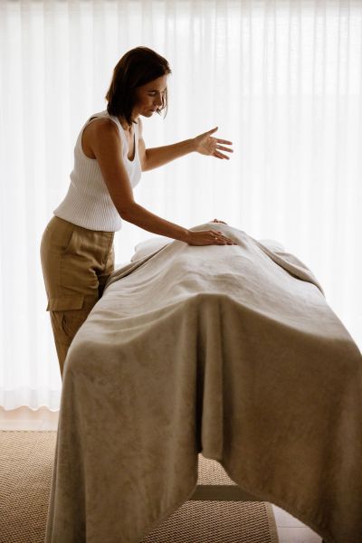 Woman giving a massage covered with a blanket.
