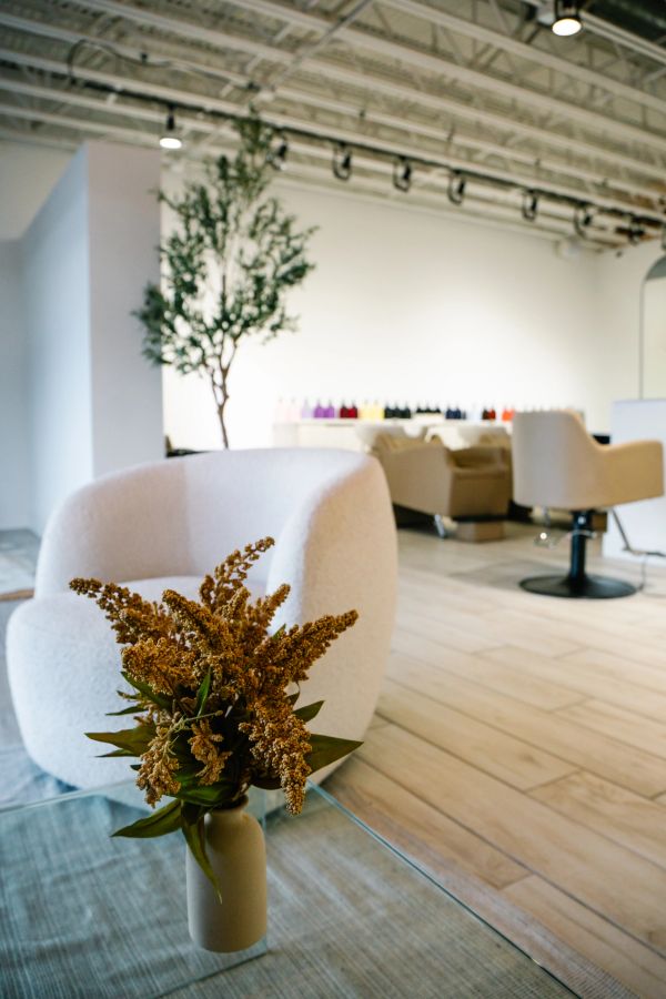 Cozy seating area with chairs and a vase of dried flowers.