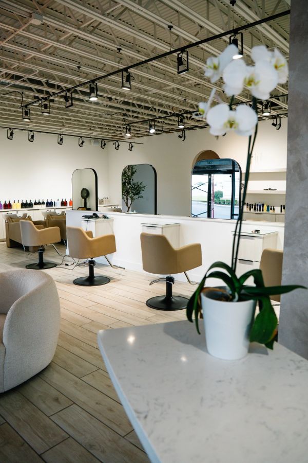 Modern salon interior with beige chairs and track lighting.