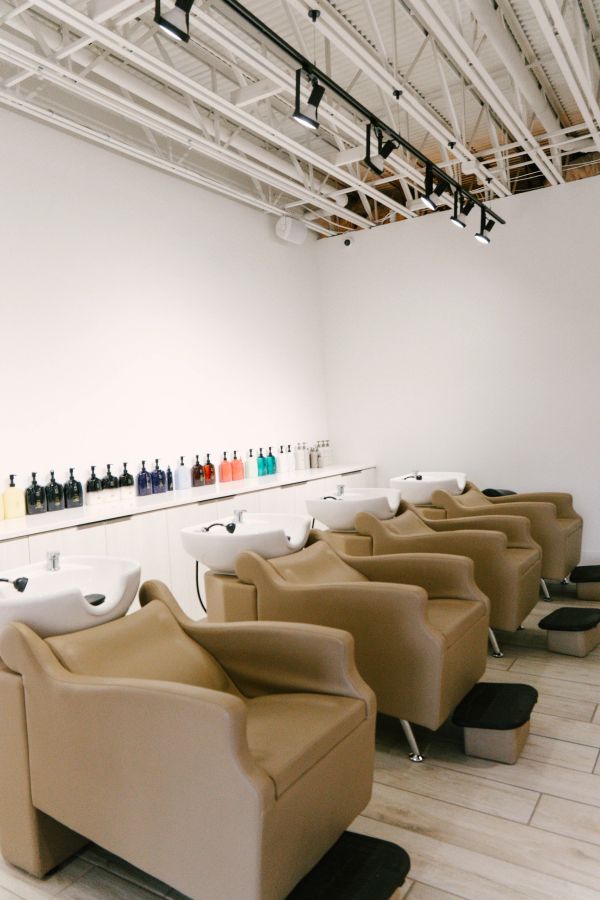 Modern salon washing stations with comfortable chairs.
