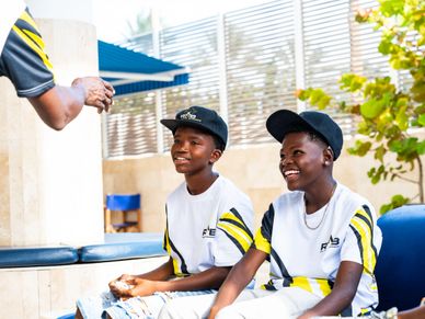Two boys in matching shirts share a joyful moment outdoors.