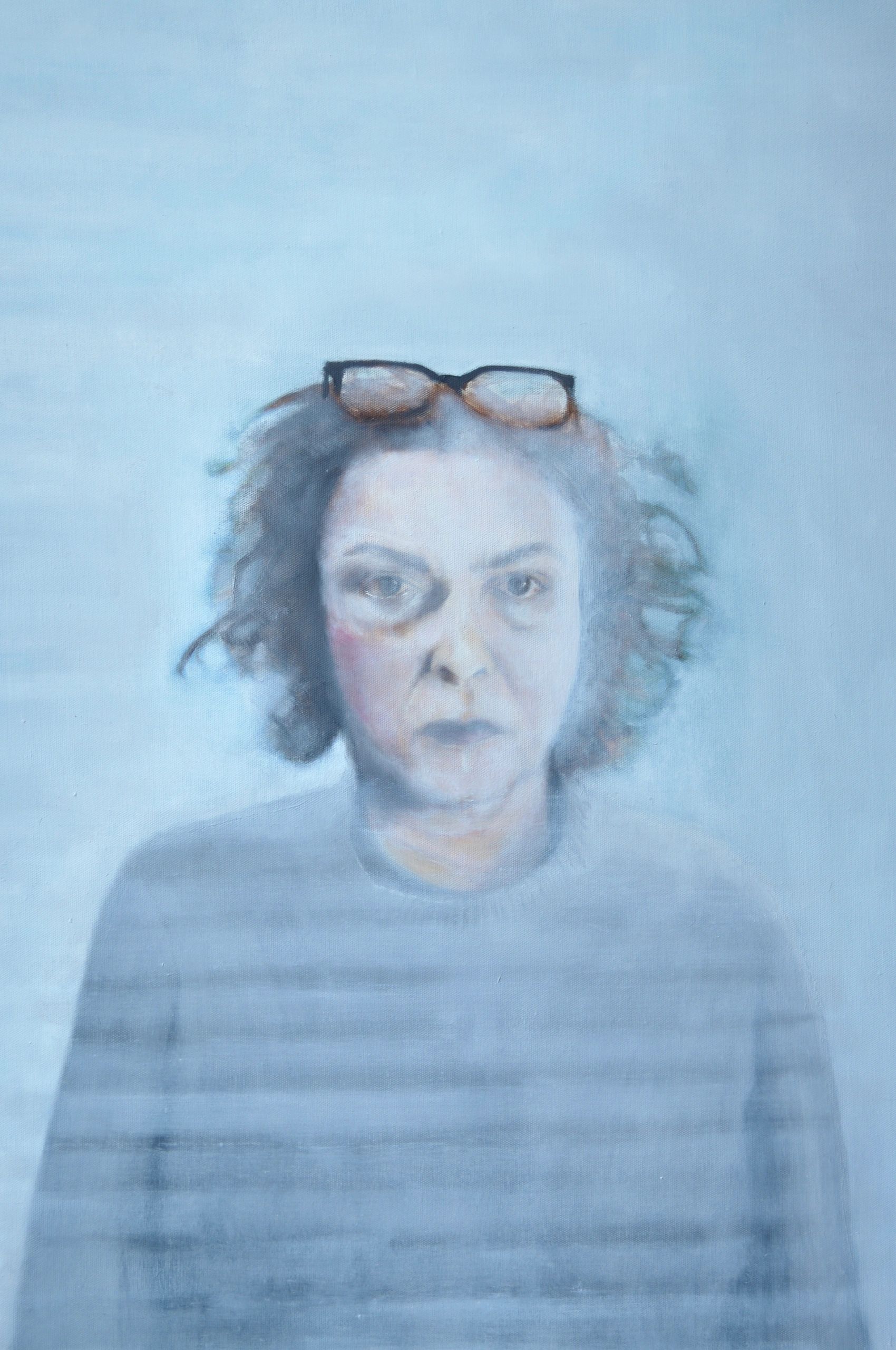 Portrait flou d'une femme avec des lunettes sur la tête.