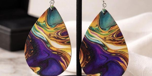 Colorful teardrop earrings with abstract swirl design in purple, gold, and teal.