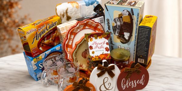 Holiday-themed gift basket with drinks and decor.