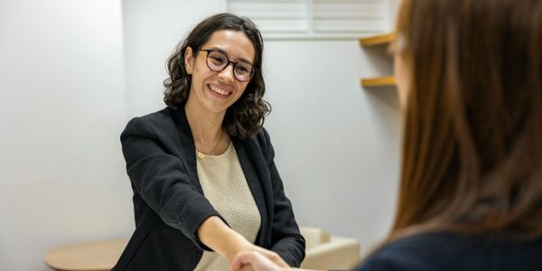 Two women shaking hands during a professional meeting.