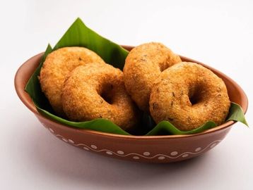 Beignets croustillants aux lentilles frites avec oignons, piments verts et feuilles de curry, servis