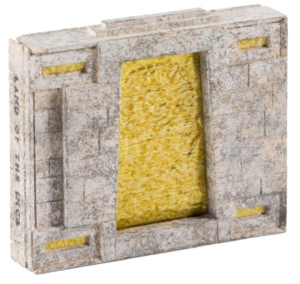 A small stone-like rectangular block with a yellow textured center and worn edges.