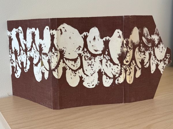 Abstract brown and white patterned artwork on a folding surface.