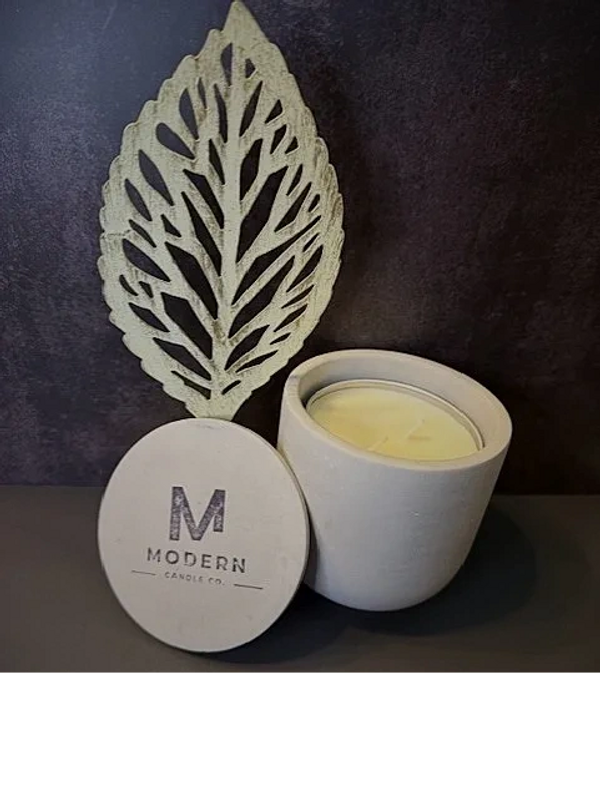 Modern Candle Co. soy candle in a minimalistic container with decorative leaf.