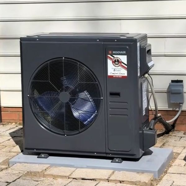 A modern outdoor air conditioning unit installed on a concrete slab.