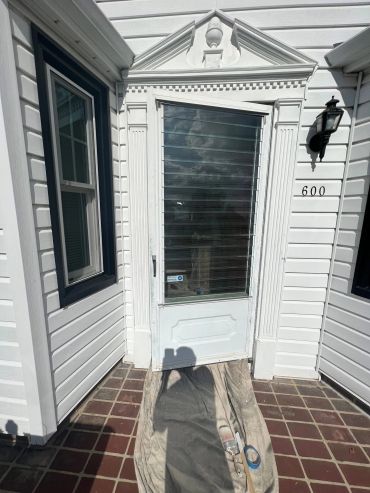 Front door of a white house with number 600.