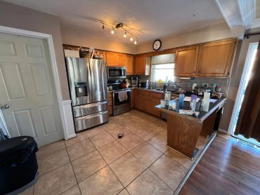 Clean kitchen with wooden cabinets and stainless steel appliances.