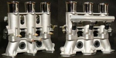 Two silver engine intake manifolds on a black background.