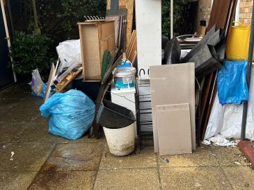Pile of discarded household items and trash bags.
