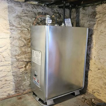 A metal oil furnace or boiler unit installed in a basement corner.