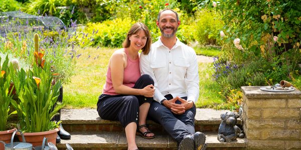 A happy couple sitting in a sunny garden.